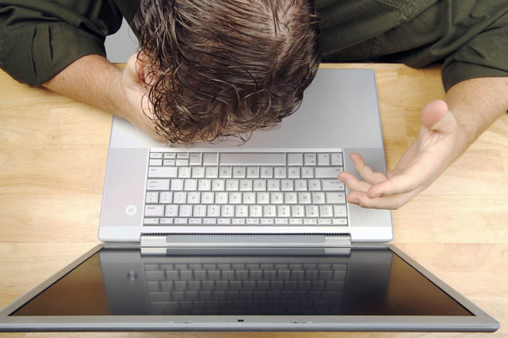 Businessman shows his frustration while working on his laptop.